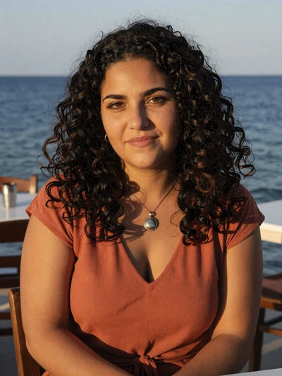 Katerina, 29, a Greek woman with curly black hair at a seaside taverna in Heraklion Crete