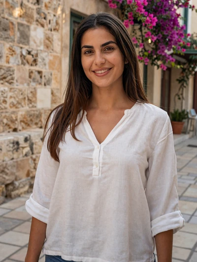 Elena, 29, a Cypriot woman with dark hair smiling on a Nicosia old town street with bougainvillea