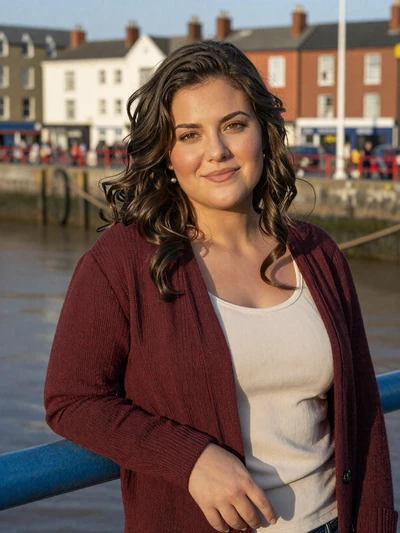 Olivia, 32, a dark-haired British woman at Bristol harbor during golden hour
