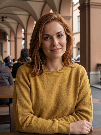 Sofia, 29, a confident Italian woman at a cafe under Bologna porticoes