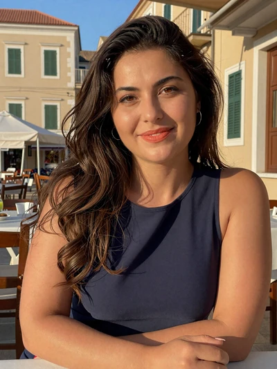 Anastasia, 36, a warm Greek woman sitting at an outdoor restaurant in Corfu old town